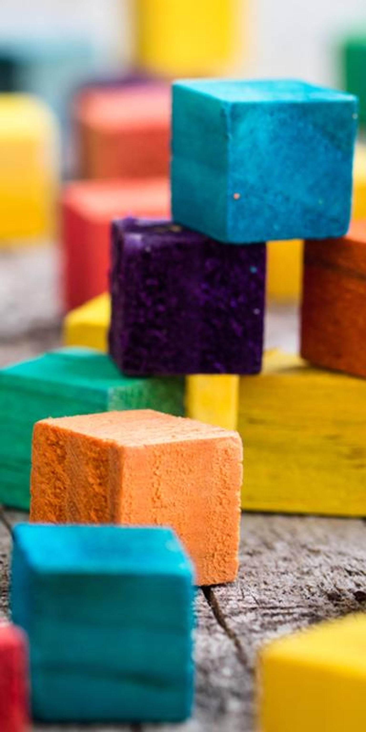 Child's coloured building blocks stacked unevenly on top of each other