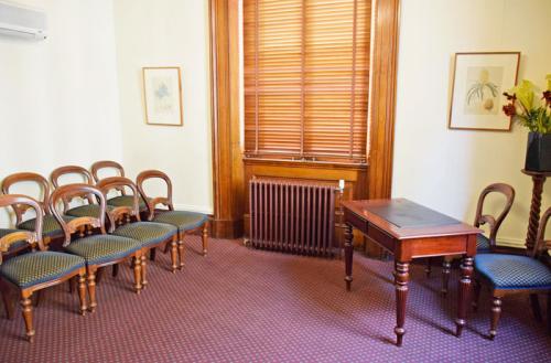 Two rows of four chairs each, facing the celebrant's desk and chair