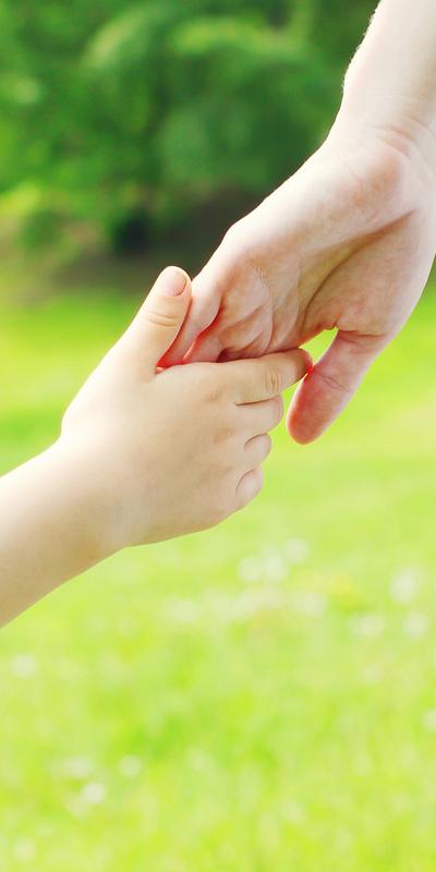 Child's hand reaching up to hold an adult's hand